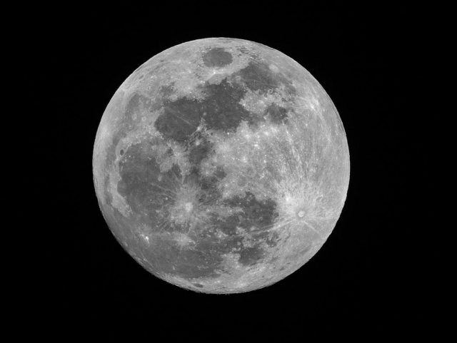 NASA Releases Apollo 12 Transcript Detailing Unidentified Lunar Phenomena Apollo 12 astronauts in space suits inside the lunar module, with the Moon visible through a window, as they observe strange lights through an optical telescope.