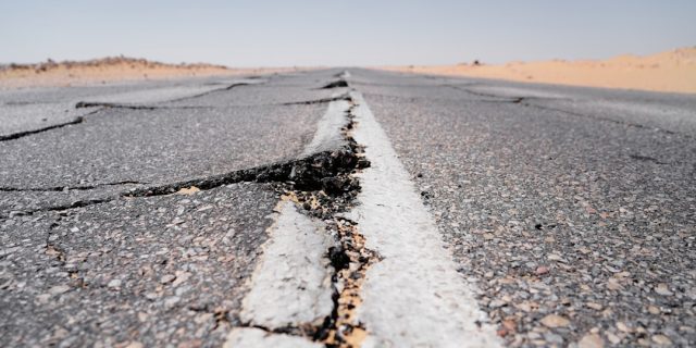 California's Long Earthquake History Contextualizes Recent Ojai Quake Cracked asphalt on a quiet Ojai street after the 2023 quake, with residents inspecting minor damage under sunny skies.